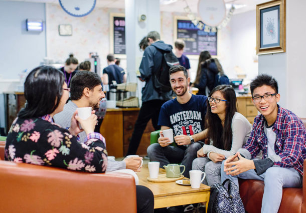 A group of students chatting and drinking coffee at the Global Café