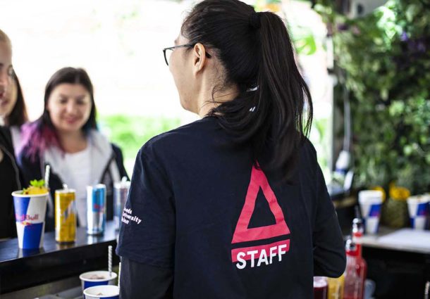 A woman in a Pyramid Canteen t-shirt serves customers