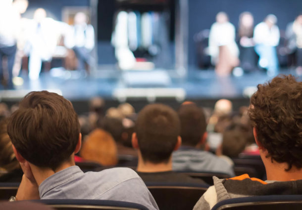 View of the back of an audience at a theatre