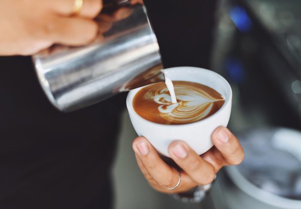 A barista doing latte art on a coffee