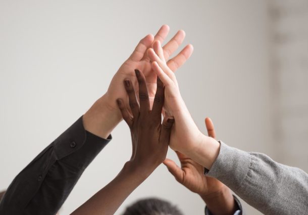A group of hands high-five each other