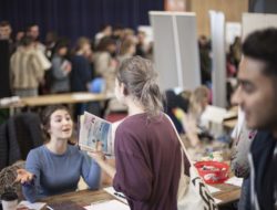 A woman talking to a stall holder at a Freshers' Fair