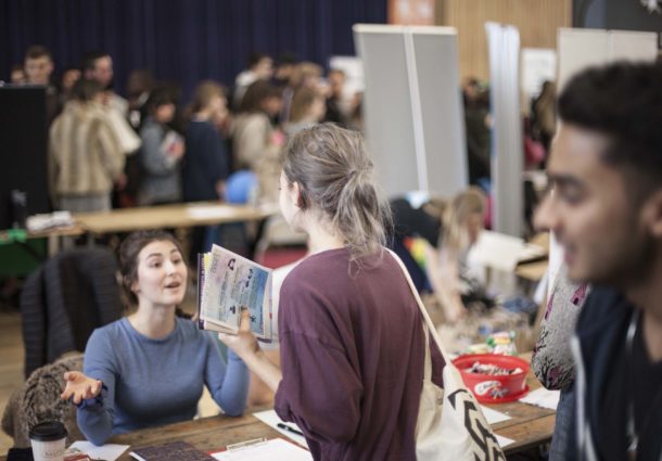 A woman talking to a stall holder at a Freshers' Fair