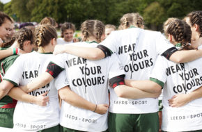 A women's sports team huddle together for a team talk