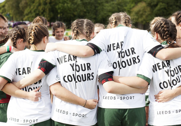 A women's sports team huddle together for a team talk