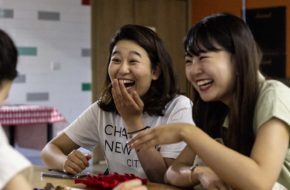 A group of students at a table laughing during a crafting session