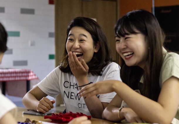 A group of students at a table laughing during a crafting session