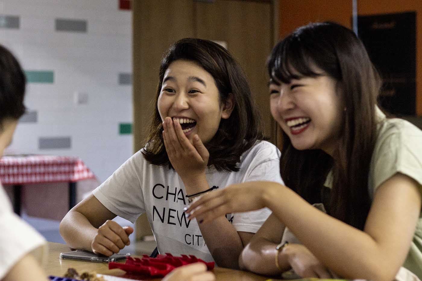 A group of students at a table laughing during a crafting session