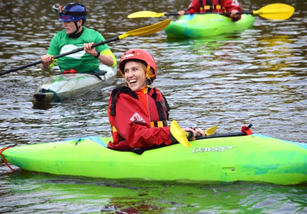 A woman smiling whilst in a kayak