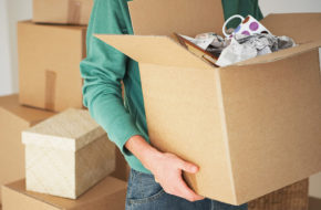 A man holding a box of possessions while moving out