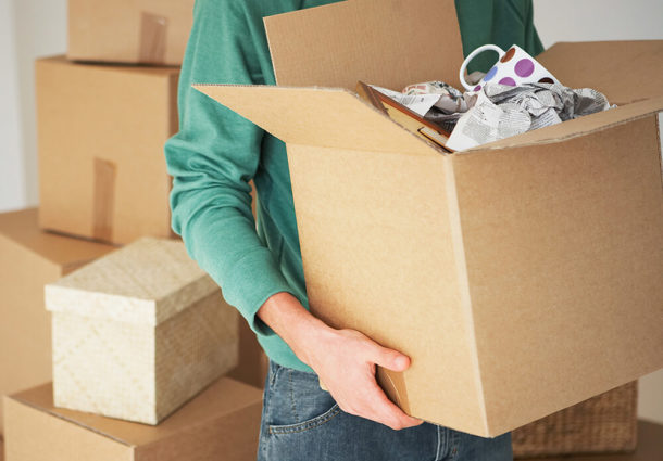 A man holding a box of possessions while moving out