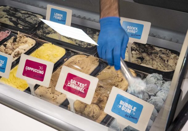 An employee scooping ice cream from a tub in the desert shop 'Scream'