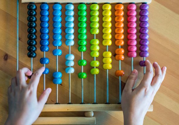 Two hands use a colourful abacus