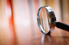 Closeup of a magnifying glass on a wooden table