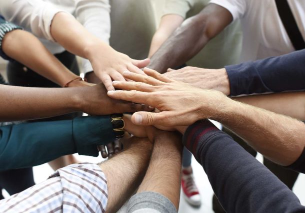 Several hands joined together in the middle of a circle