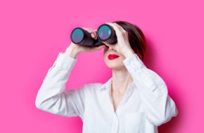 A picture of a woman with binoculars on a pink background