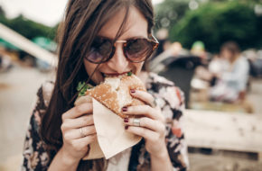 A woman biting into a burger