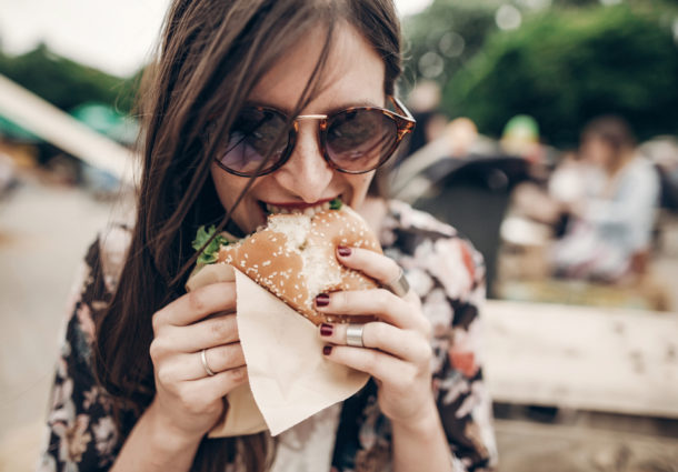 A woman biting into a burger