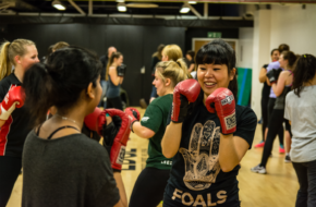 Two women sparring during a boxing session