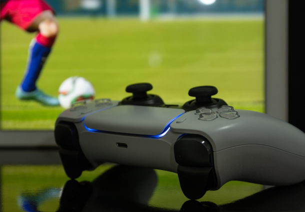 A games controller in front of a TV playing football
